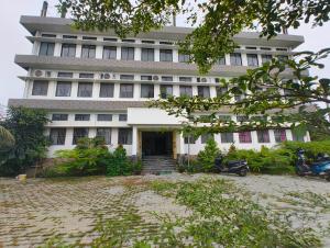 a large white building with a lot of windows at Premium AC Rooms at Taj Heritage Hotel and Restatrant in Jorhat