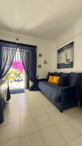 un soggiorno con un divano blu e una finestra di Fay's paradise a Polykhrono Altre 39 foto