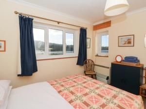 a bedroom with a bed and two windows at Bryncyn in Newport