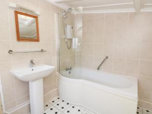 a bathroom with a tub and a sink and a bath tub at Bryncyn in Newport +29 photos