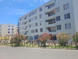 un grande edificio bianco con dei fiori di fronte di Sector Norte 1 Dormitorio ad Antofagasta