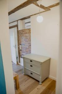 eine weiße Kommode in einem Zimmer mit Ziegelwand in der Unterkunft Appartement mit Connection am Müritz- Nationalpark 