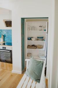 einen weißen Schrank mit einem Stuhl in einem Zimmer in der Unterkunft Appartement mit Connection am Müritz- Nationalpark 