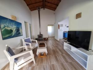 ein Wohnzimmer mit einem großen Flachbildfernseher in der Unterkunft Surf House Casa Tony Aloha Host in La Estafeta