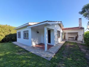 ein weißes Haus mit einer Veranda und einem Garten in der Unterkunft Surf House Casa Tony Aloha Host in La Estafeta