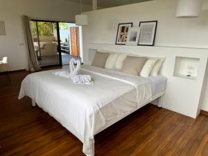 a large white bed with two white swans on it at Villas Jacquelina in Quepos