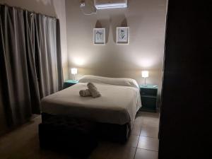 een slaapkamer met een bed met twee nachtkastjes en twee lampen bij Posada Abrazo Serrano en Carpintería in Carpintería