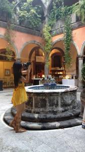 a little girl taking a picture of a fountain at Casa Relox 23 in San Miguel de Allende