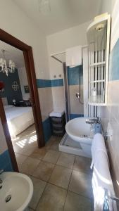 a bathroom with a sink and a toilet and a bed at Blue Dolphin Guest House in Alghero