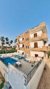 un'immagine di un edificio con piscina di Sun wing guest house a Luxor