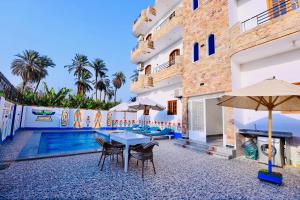 a patio with tables and chairs next to a building at Sun wing guest house in Luxor