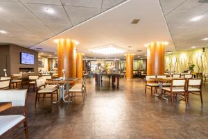 um restaurante com mesas e cadeiras em uma sala em Stream Hotéis em Ribeirão Preto