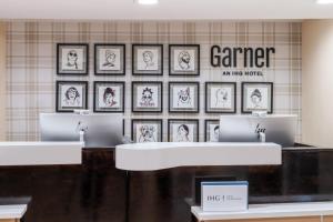 维多利亚Garner Hotel Victoria - East by IHG的一家商店，墙上挂着装裱好的照片。