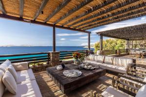 a patio with a table and chairs and the ocean at Villa Macaro with Direct Beach Access in Mikonos