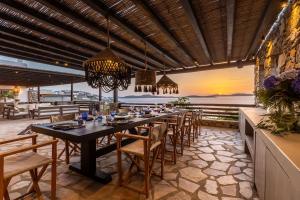 a dining room with a long table and chairs at Villa Macaro with Direct Beach Access in Mikonos