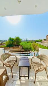 un patio con due sedie e un tavolo su un balcone di Sun wing guest house a Luxor