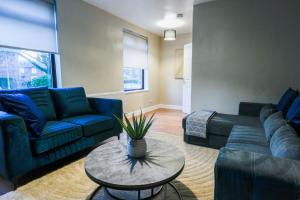 a living room with blue couches and a table at Victory House in Gretna