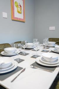 a table with white plates and wine glasses on it at Victory House in Gretna