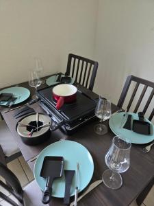 a table with plates and glasses on top of it at Zimmer mit Herz in Schwyz +11 photos
