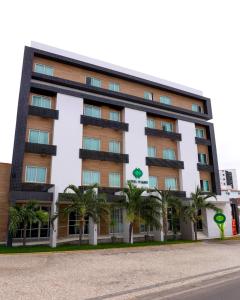 un edificio con delle palme di fronte di Oasis Hotel a Cajazeiras