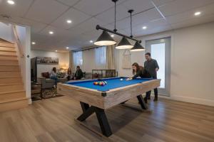 a group of people playing pool in a room at Spa & Pool table - Le Massif in Saint Adolphe D'Howard