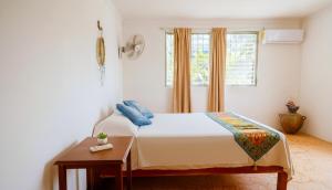 Schlafzimmer mit einem Bett, einem Fenster und einem Tisch in der Unterkunft Casa Nido Bacalar in Bacalar