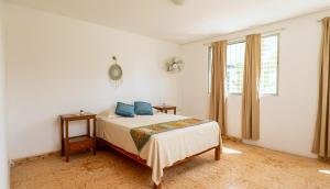 ein Schlafzimmer mit einem Bett mit blauen Kissen darauf in der Unterkunft Casa Nido Bacalar in Bacalar