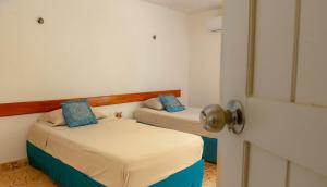 twee bedden in een kamer met een deur open bij Casa Nido Bacalar in Bacalar