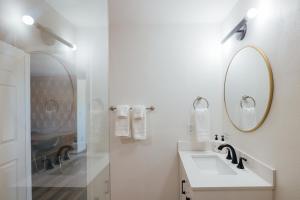 a white bathroom with a sink and a mirror at Wanderlust- Desert Escape Stargazing Fire Pit in Twentynine Palms +73 photos