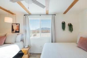 a bedroom with two beds and a window at Wanderlust- Desert Escape Stargazing Fire Pit in Twentynine Palms