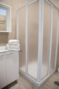 a bathroom with a glass shower stall with a mirror at Nexo Surf House in El Palmar +47 photos