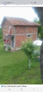 een stenen huis met een kleine boom in de tuin bij Katun in Kosovska Mitrovica