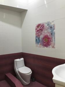 Un baño con inodoro y un cuadro en la pared. en Leila, en Tiflis 20 fotos más