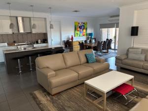 een woonkamer met een bank en een keuken bij Lakeside Nagambie 4guests in Nagambie