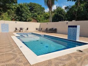 a swimming pool with blue water in a yard at Hotel San Andres in Coronel Oviedo