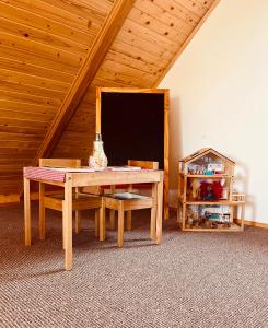 una camera con tavolo e sedie in mansarda di Brvnara Duga njiva a Čelinac