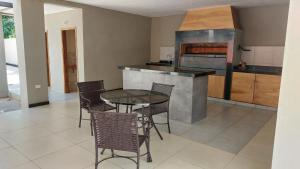 a kitchen with a table and chairs and a stove at Hotel San Andres in Coronel Oviedo