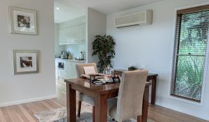 een eetkamer met een houten tafel en een keuken bij Wild Edge Retreat in Wollombi