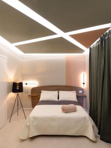 een slaapkamer met een groot bed met verlichting aan het plafond bij Cozy Rooms in Senorbì