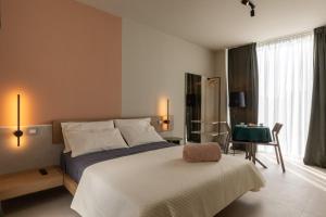 a bedroom with a large bed and a table at Cozy Rooms in Senorbì
