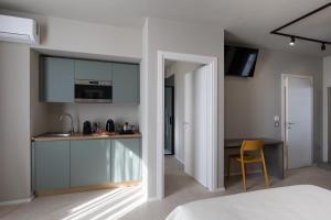a bedroom with a kitchen with a table and a chair at Cozy Rooms in Senorbì