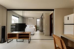 un soggiorno con un letto e una televisione di Jubarte Flats a Itacaré