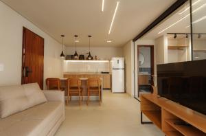 un soggiorno con divano e cucina di Jubarte Flats a Itacaré