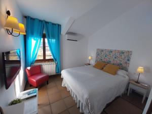 ein Schlafzimmer mit einem Bett und einem roten Stuhl in der Unterkunft Casa Rural, Spa y restaurante El Huerto del Abuelo in Almiruete + 72 Fotos