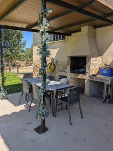 un patio con tavolo, sedie e forno in pietra di Aldea de Cabañeros a El Robledo