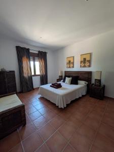 una camera da letto con un letto e un pavimento piastrellato di Aldea de Cabañeros a El Robledo Altre 25 foto