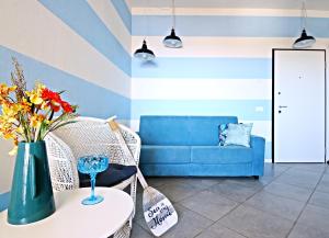 ein Wohnzimmer mit einem blauen Sofa und einem Tisch mit Blumen in der Unterkunft 3palme in Follonica