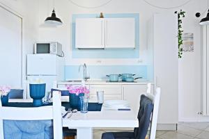 eine Küche mit blauen Wänden und einem weißen Tisch in der Unterkunft 3palme in Follonica