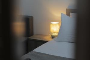 a bedroom with a bed and a lamp on a night stand at La Casa in Kozani