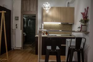 a kitchen with two chairs and a counter and cabinets at La Casa in Kozani